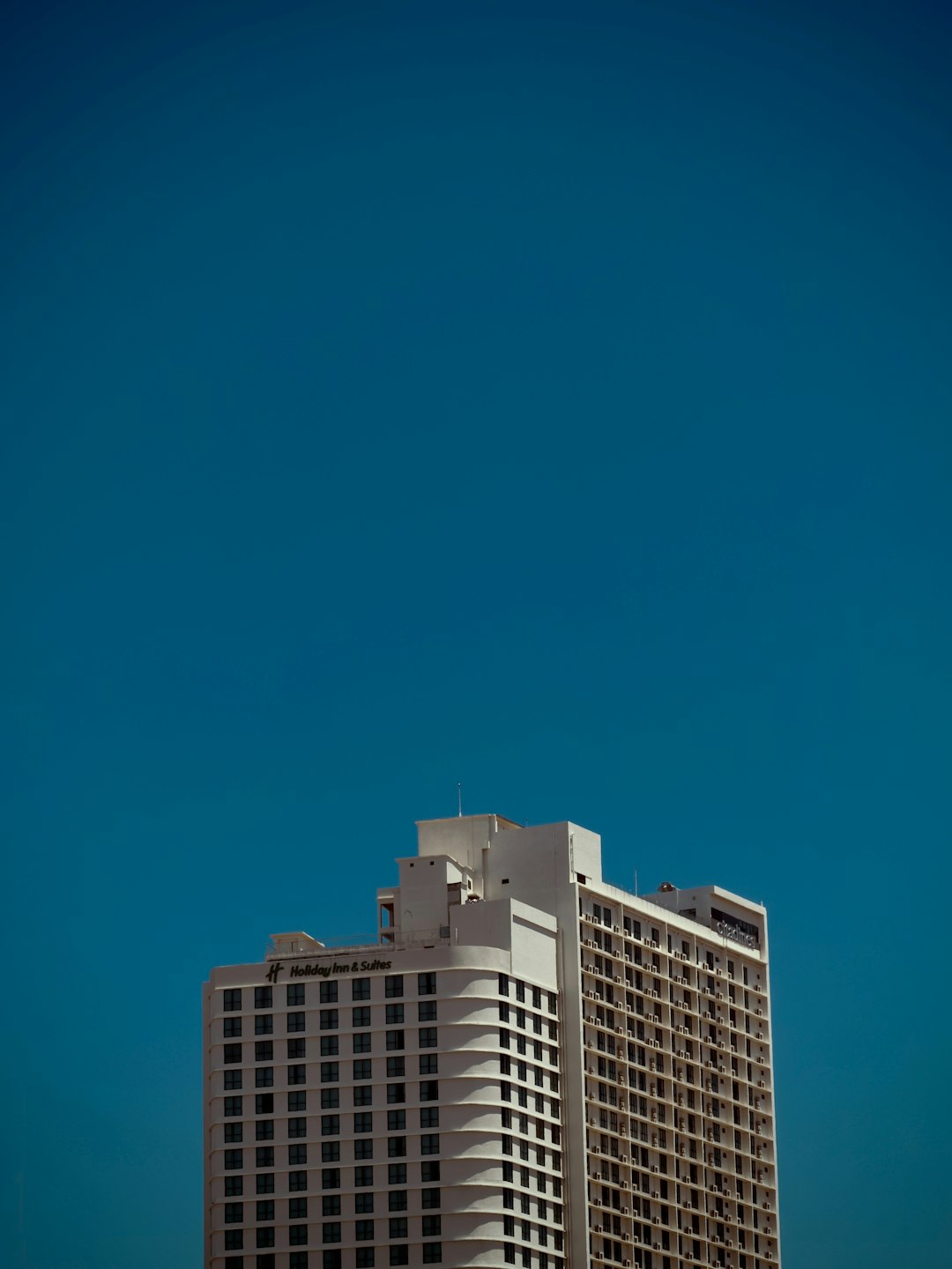 tall-white-building-against-a-clear-blue-sky-wqtxlmx-axw